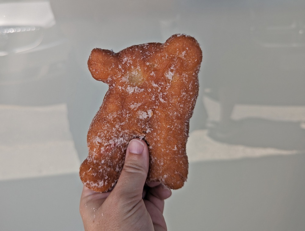 Hand holding up a Jelly Pig donut from Leinala's Bakery