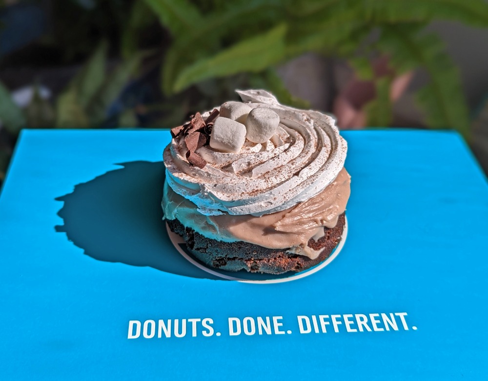 Smore donut from Maverick's sitting on a blue box that says 'Donuts Done Different'
