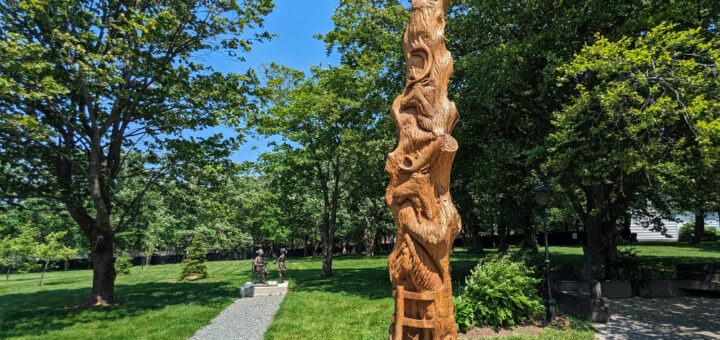 The Living Tree, which is a carved tree with various Newfoundland animals carved in it, surrounded by trees.