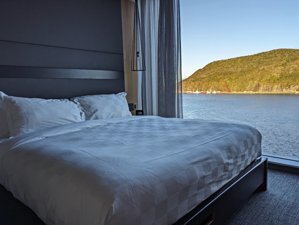 Alt Hotel king sized bed with a massive window beside it with views of St. John's Harbour.