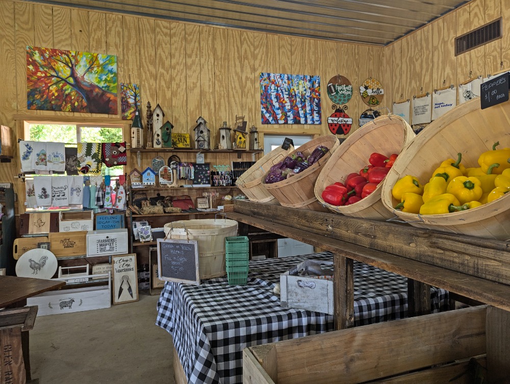 Inside Tindall Farm & Market with baskets of fresh vegetables and other artisan products on shelves in the background.