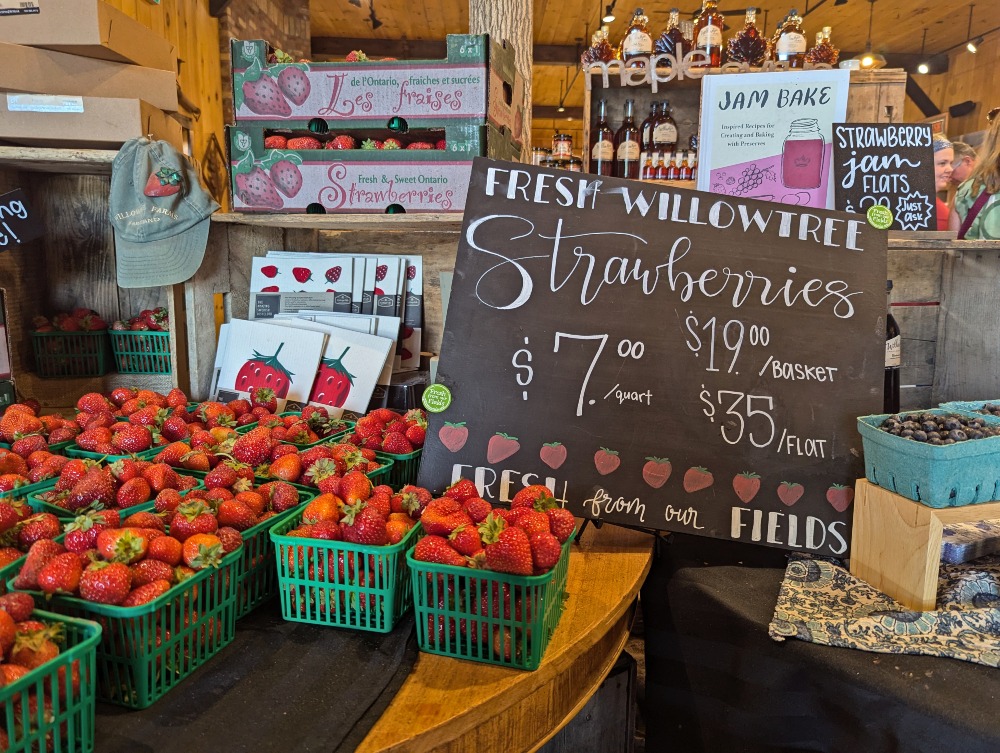 Williowtree Farm strawberries in small baskets on a shelf.