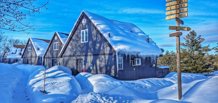 A row of cottages in Muskoka with a ton of snow around them.