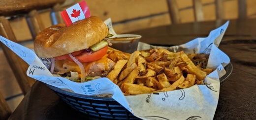 Hoser burger and fries with a tiny Canada flag on the burger from M.I.C. Canadian Eatery - one of the best restaurants in Sudbury