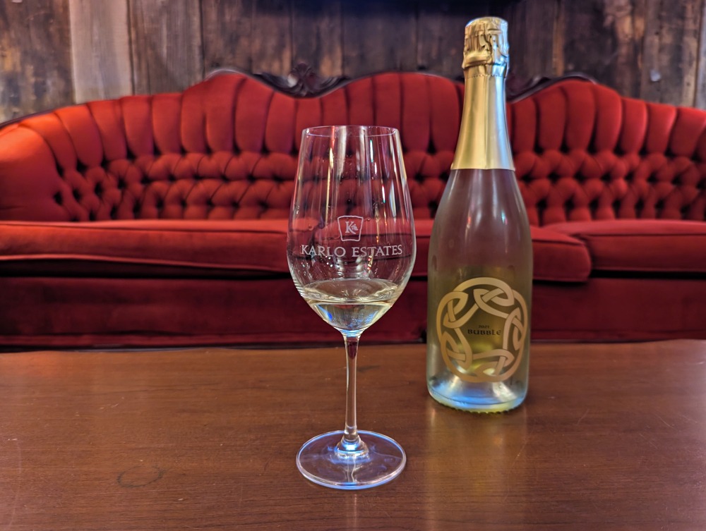 Glass of wine and bottle sitting on a table at Karlo Estates winery in Prince Edward County