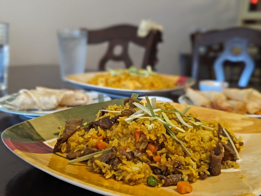 fried rice plate of Thai food with other dishes in the background at Pho Hut