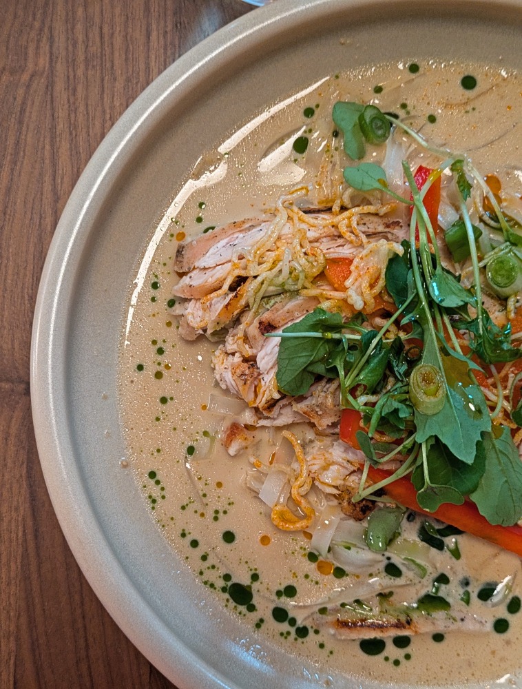 Asian dish with chicken, curry and greens at Loqui