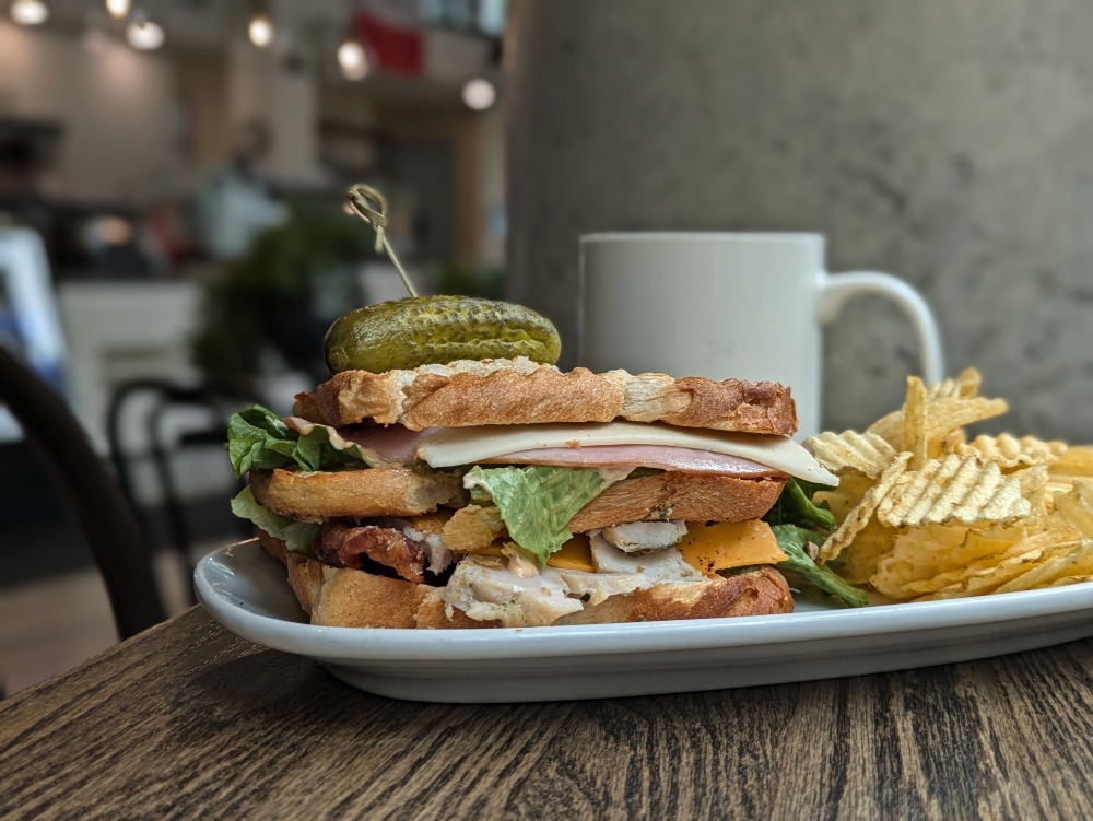 Large sandwich with chips on a plate at HomeQuarter Coffeehouse & Bakery