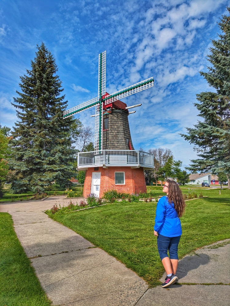 Woman standing in front of a windmill in International Friendship Gardens