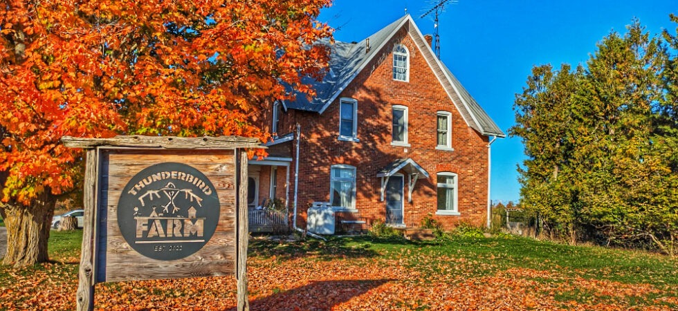 Thunderbird Farm farmhouse and sign in the fall