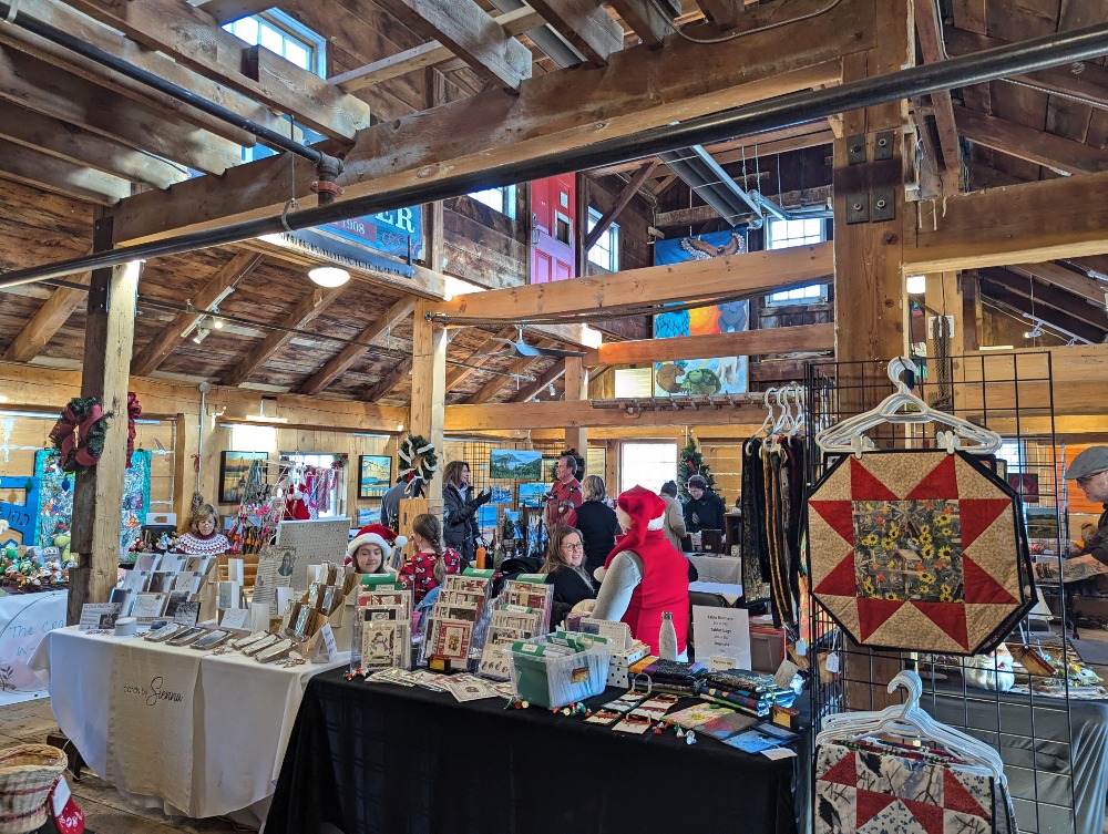 On the top floor of the Coldwater Mill for their Christmas market, with wood beams and various booths selling items