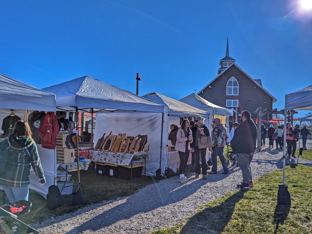 Outdoor Christmas market at Quayle's Brewery with various tents set up selling items