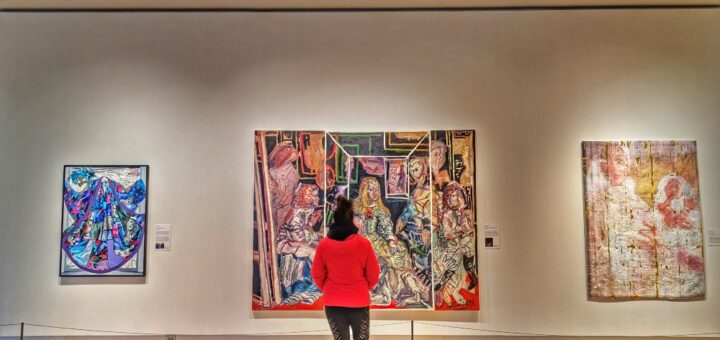 Me standing in front of a wall of art at the Robert McLaughlin Gallery in Oshawa