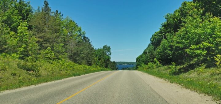 Georgian Bay road trip with tree lined road and views of the water in the distance