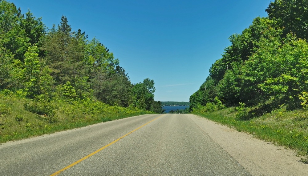 Georgian Bay road trip with tree lined road and views of the water in the distance