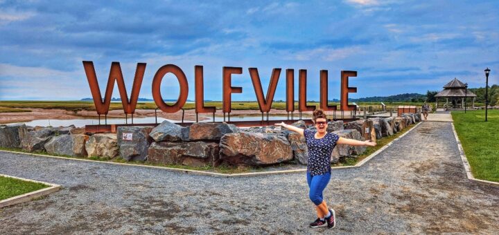 me standing in front of the Wolfville sign in Waterfront Park