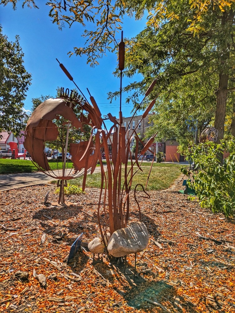 metal sculptures, a bird, cattails, and a globe, in Sculpture Park in Clinton