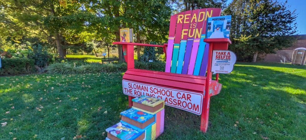 One of the Giant Chairs in Clinton with steps made out of books, surrounded by parkland
