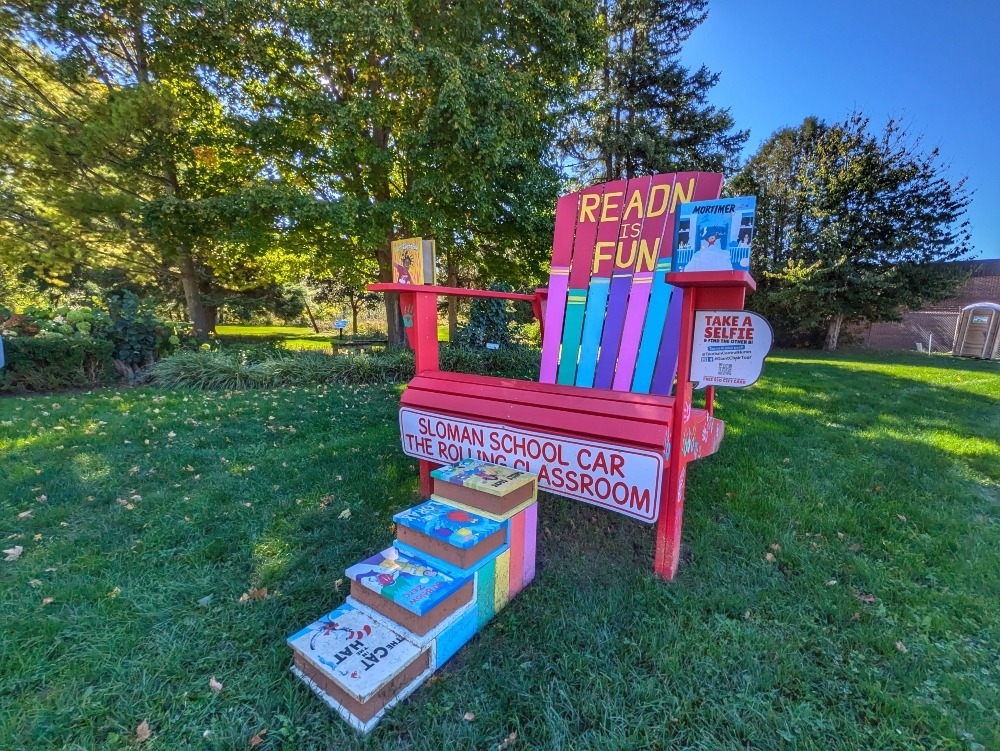 One of the Giant Chairs in Clinton with steps made out of books, surrounded by parkland