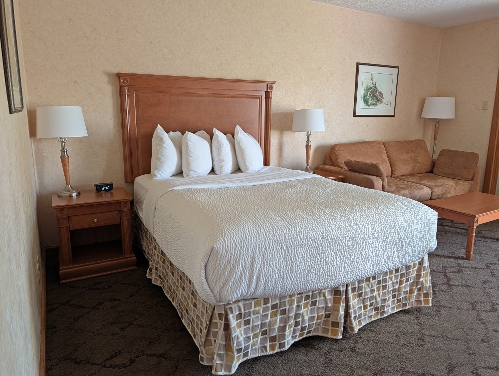 Hotel room with bed and couch at Best Western Plus Otonabee Inn in Peterborough