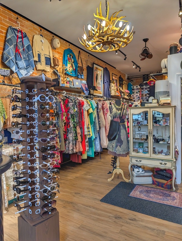 Interior of vintage shop called Statement House with sunglass rack and clothing