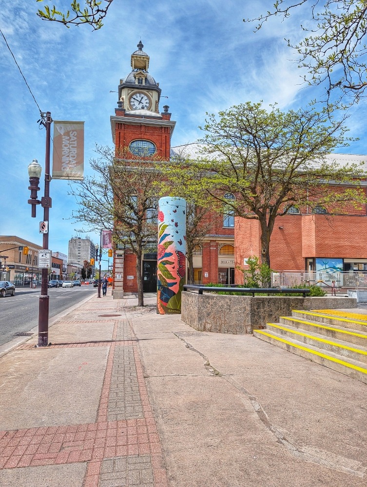 Sidewalk leading up to a historic building in downtown Peterborough with clock tower
