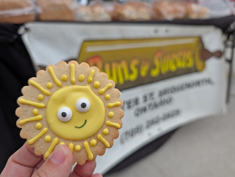 Sun cookie in front of Buns & Sweets vendor at Peterborough's Regional Farmers Market