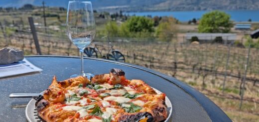 Pizza and glass of wine at Chain Reaction Winery in Penticton. The view is of the lake and mountains