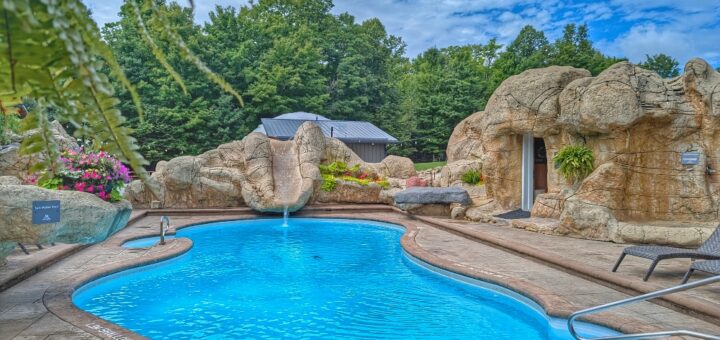 pool at Maplestone Ranch & Retreat with a slide and looks like its surrounded by a grotto