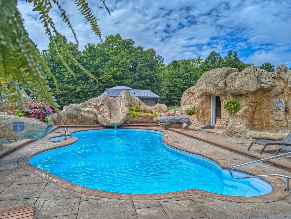 pool at Maplestone Ranch & Retreat with a slide and looks like its surrounded by a grotto