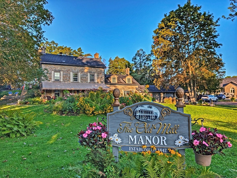 Exterior of the Old Mill Manor with gardens and stone home, which is one of the best places to stay in Almonte