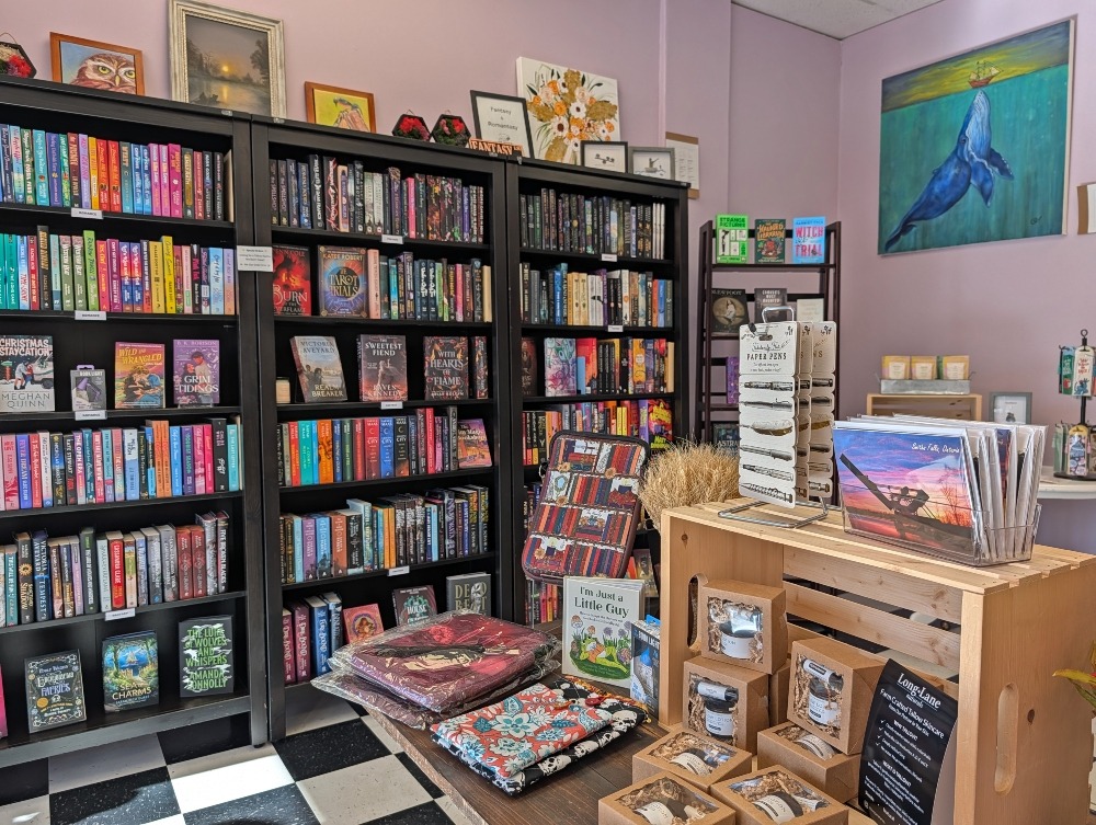 Bookshelves and table full of books and items at The Book's Better Bookshop