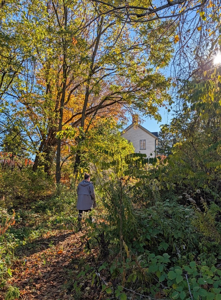 Lady walking through the woods at Heritage House Museum