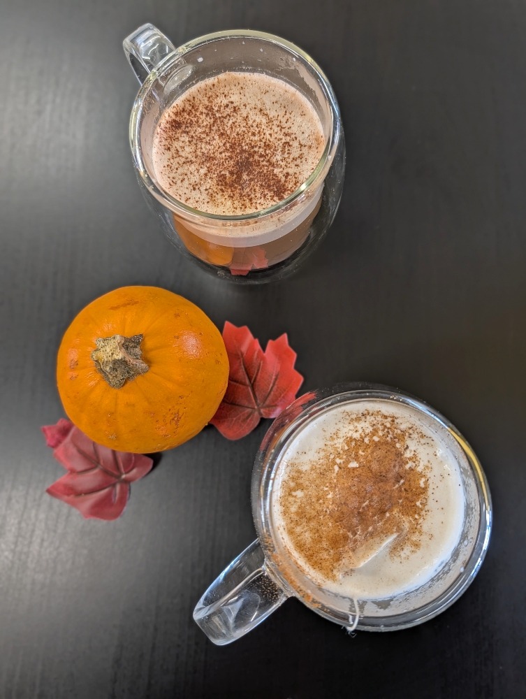 two lattes and a little pumpkin on a table at Amaya Cafe